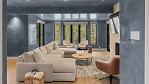 A modern living room with a sectional sofa, a round coffee table, and a fireplace.