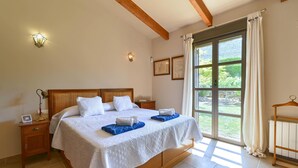 A well-lit bedroom with a large bed, bedside tables, and a view through a large window. - Alondra - Javea, Costa Blanca (Javea)