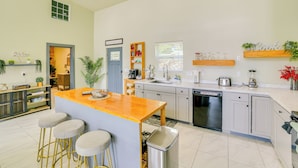 A modern kitchen with a central island, bar stools, a dishwasher, and a sink. - Lake Taneycomo Views: Family-Friendly Cabin! (Forsyth)