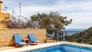 A swimming pool with two sun loungers, a stone wall, and a view of the sea. - Altea Buganvillas - Altea, Costa Blanca (Altea)