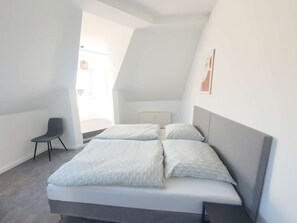 A bedroom with a bed, a chair, and a radiator. - Bright and Spacious 100 m², 5-Room Holiday Apartment with Style & Comfort (Solingen)