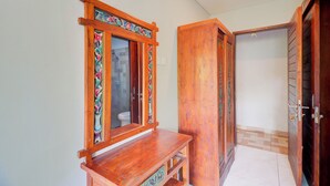 A hallway with wooden doors and a bench. - Collection O Bali near Sanur Beach formerly Akarsa Kokoro (Denpasar)
