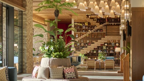 A modern interior with a staircase, a seating area with a plant, and a bookshelf. - The Royal Park Hotel Maihama Resort Tokyo Bay (Urayasu)