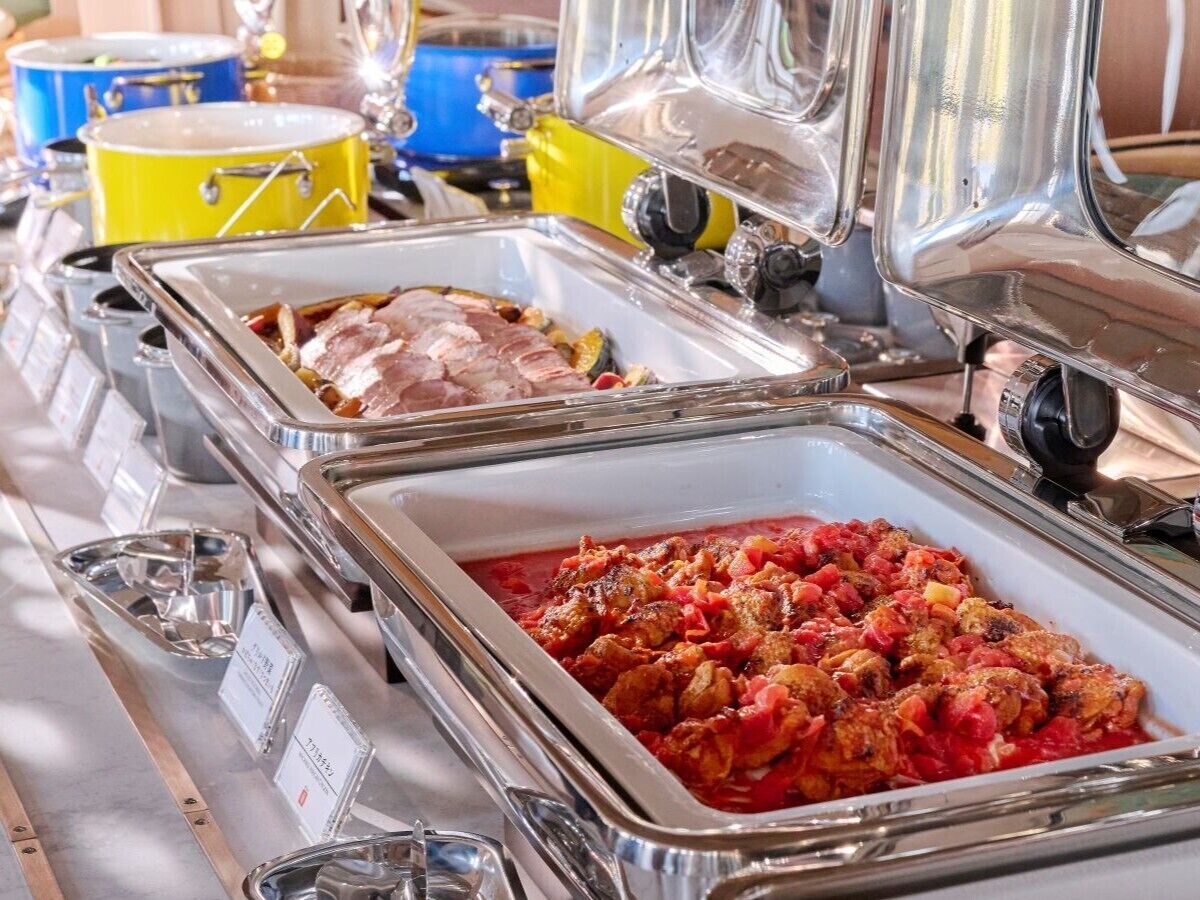A buffet with various dishes in clear serving dishes.