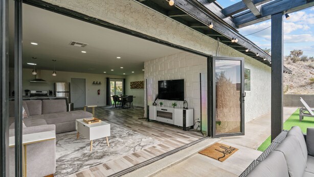 Una sala de estar moderna con televisor de pantalla plana, un sofá, una mesa de centro y una chimenea.