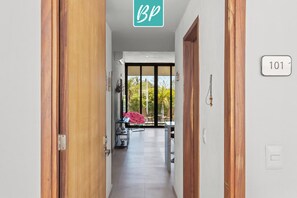 A hallway with a wooden door on the left, a sign with "BP" above it, and a number "101" on the right wall.