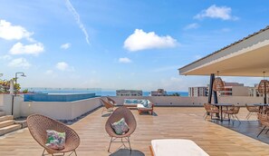 A rooftop terrace with a pool, wicker furniture, and a view of the sea. - 2BR, Rooftop Pool w/ Views, & Parking: Vista 101 (Bucerías)