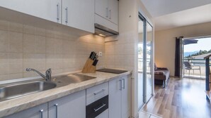 A modern kitchen with a built-in sink, stainless steel faucet, and a knife block. - Apartments Nmn Drvenik (Gradac)