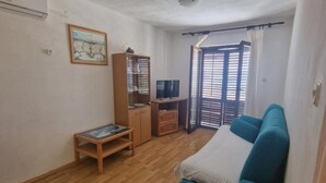 A room with a bed, a TV, a wardrobe, and a window with blinds. - Lora Apartments Gradac (Gradac)
