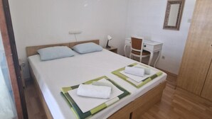 A bedroom with a bed, a desk, a chair, and a wardrobe. - Lora Apartments Gradac (Gradac)