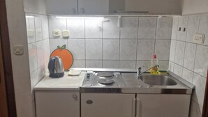 A compact kitchen with a built-in oven, a sink, and a countertop. - Lora Apartments Gradac (Gradac)