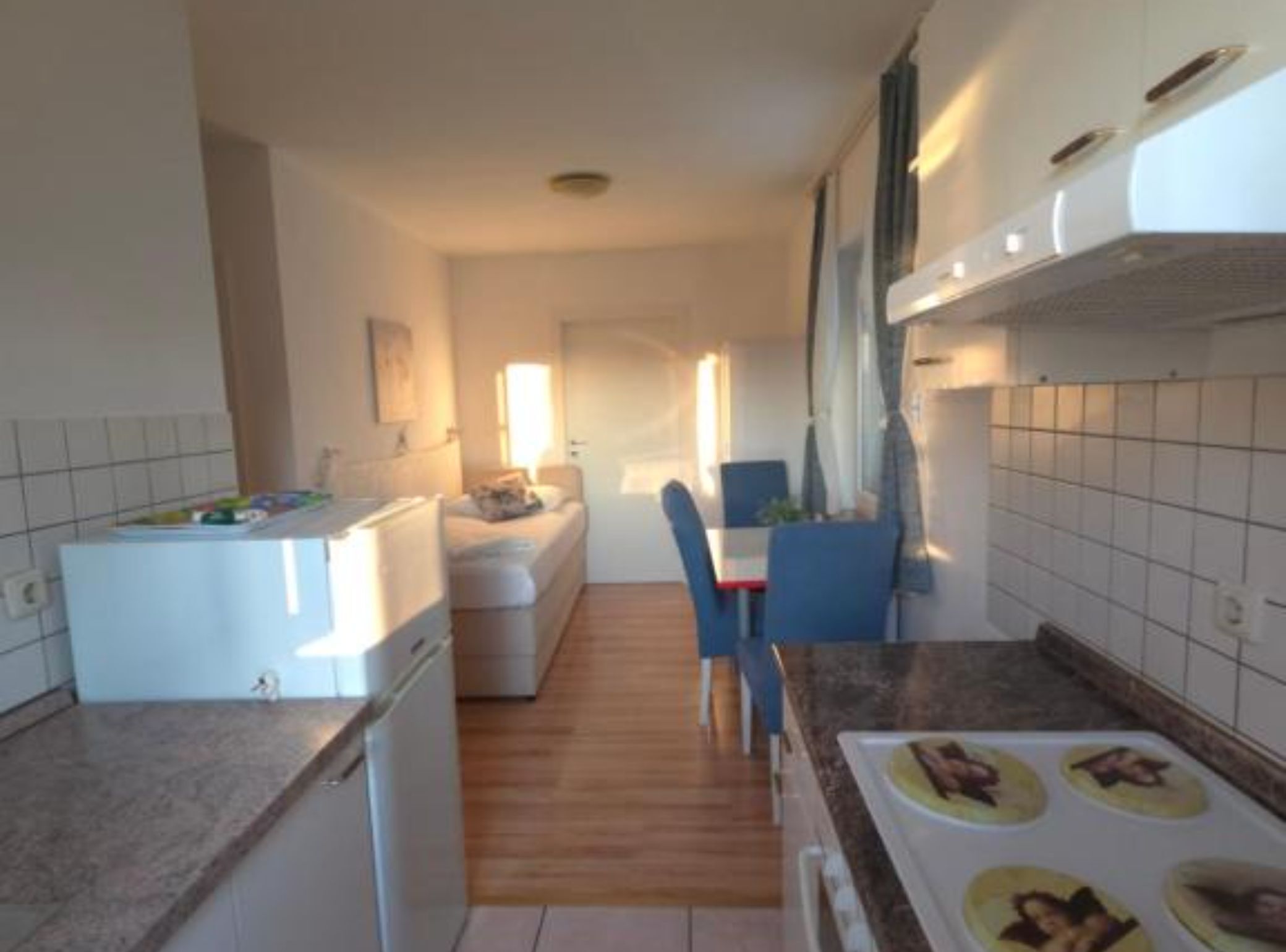A compact kitchen with a dining area, a small refrigerator, and a microwave.