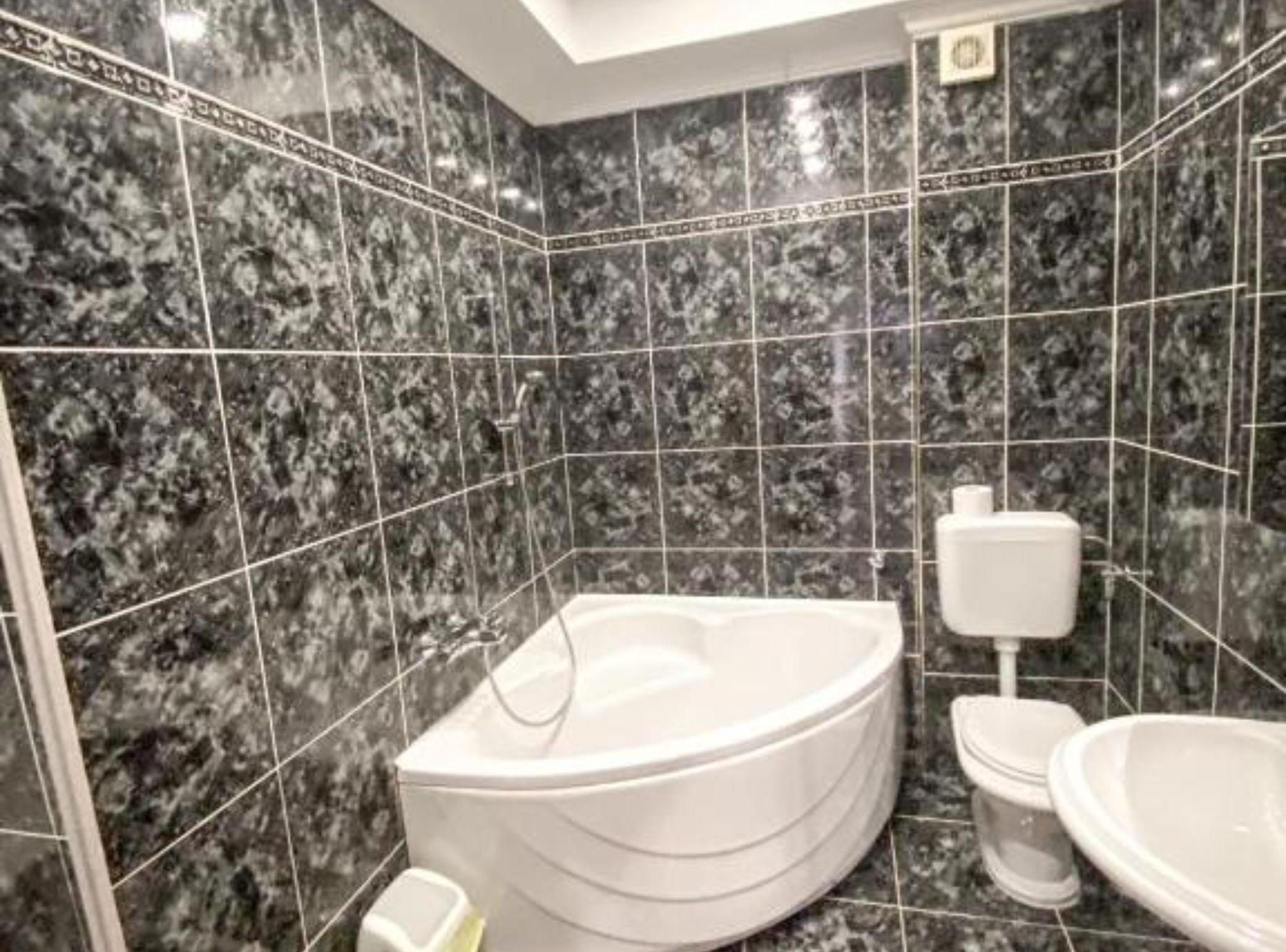 A modern bathroom with a freestanding bathtub, a toilet, and a sink.