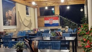An outdoor dining area with tables and chairs, a flag, and a scenic view. - Peaceful Apartments With Style (Okrug)