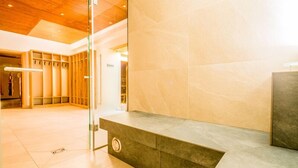 A modern lobby with a marble floor, a glass partition, and a wooden ceiling. - DAS Hubertus Apartments in Schladming (Schladming)