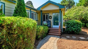 A cozy, single-story building with a welcoming entrance, a small porch, and a sign indicating a cafe.