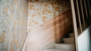 A wooden staircase with beige steps and a patterned wallpaper on the walls. - HOTEL BLEU SOLEIL (Capbreton)