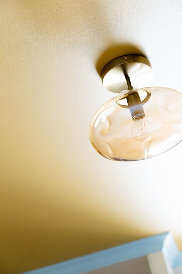 A ceiling light fixture with a clear glass shade and a metallic base. - HOTEL BLEU SOLEIL (Capbreton)