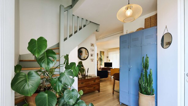 A staircase leading to a living area with a blue wardrobe, a cactus plant, and a large green plant. - Quiet family home with terrace - near Ondres beach (Ondres)