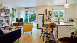 A modern kitchen with a dining area, a bookshelf, and a TV. - Quiet family home with terrace - near Ondres beach (Ondres)
