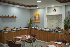 A dining area with a wooden counter, multiple seating arrangements, and a decorative wall piece.