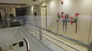 A hotel lobby with a glass railing, a reception desk, and decorative wall art. - Hotel İzgi Turhan (Batman)