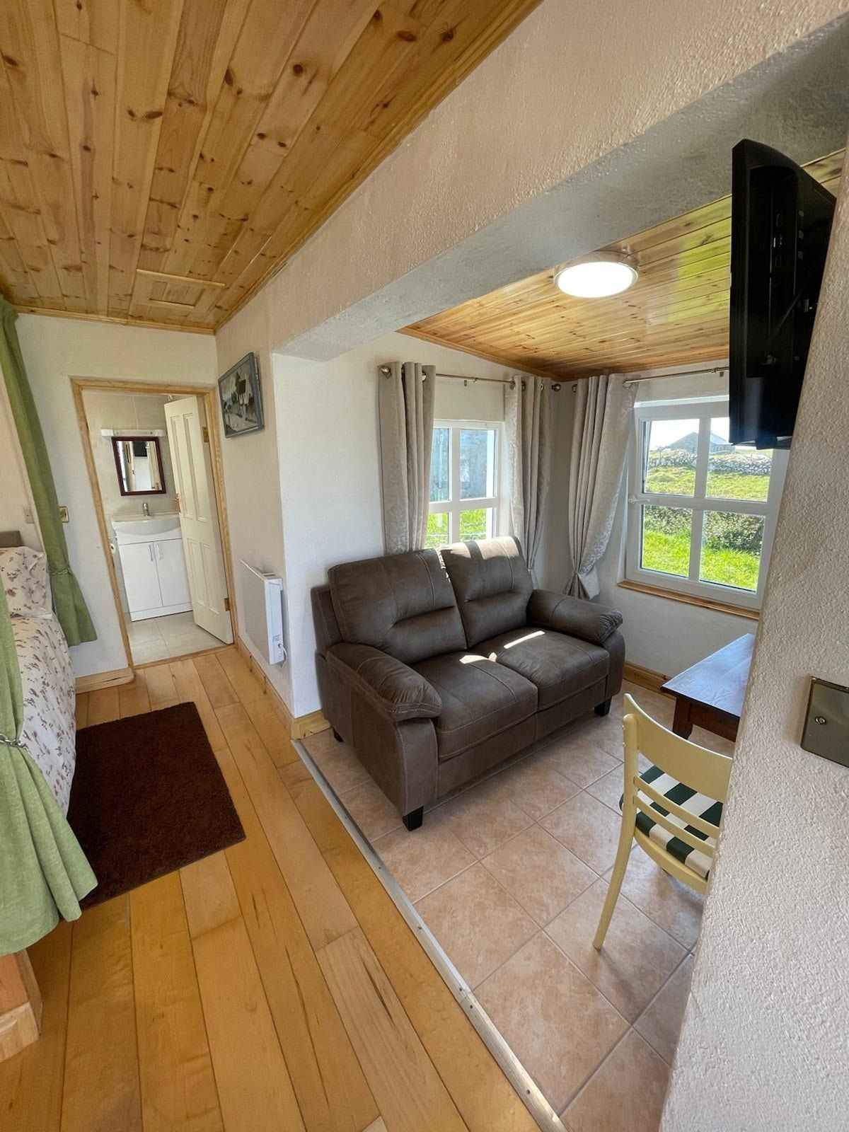 A cozy living room with a sofa, a small table, and a window with curtains.