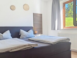 A bedroom with two beds, a window with curtains, and a radiator. - Tobias 3 by Interhome (Radstadt)