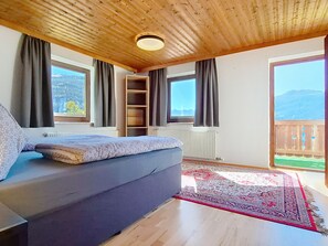 A room with a sofa, a wooden ceiling, a radiator, and a view of the outdoors. - Tobias 3 by Interhome (Radstadt)