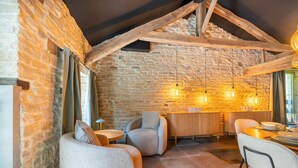 Un intérieur rustique avec des murs en pierre, des poutres en bois et des meubles modernes.