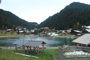 A lakeside village with wooden cabins, a wooden pier, and a picnic shelter. - Apartment by Lake in Alpenlake Residence (Châtel)