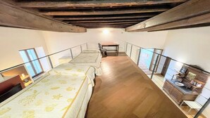 A bedroom with two beds, a desk, and a staircase. - 6 Guests apt With Terrace in Pedestrian Historic Centre of Spoleto (Spoleto)