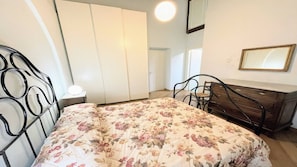 A bedroom with a bed, a dresser, a mirror, and a wardrobe. - 6 Guests apt With Terrace in Pedestrian Historic Centre of Spoleto (Spoleto)