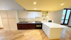 A modern kitchen with white cabinets, a built-in oven, and a microwave. - 6 Guests apt With Terrace in Pedestrian Historic Centre of Spoleto (Spoleto)