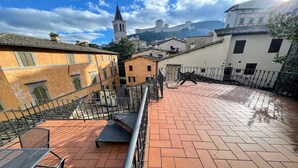 A courtyard with terracotta tiles, a metal railing, and a bench. - 6 Guests apt With Terrace in Pedestrian Historic Centre of Spoleto (Spoleto)