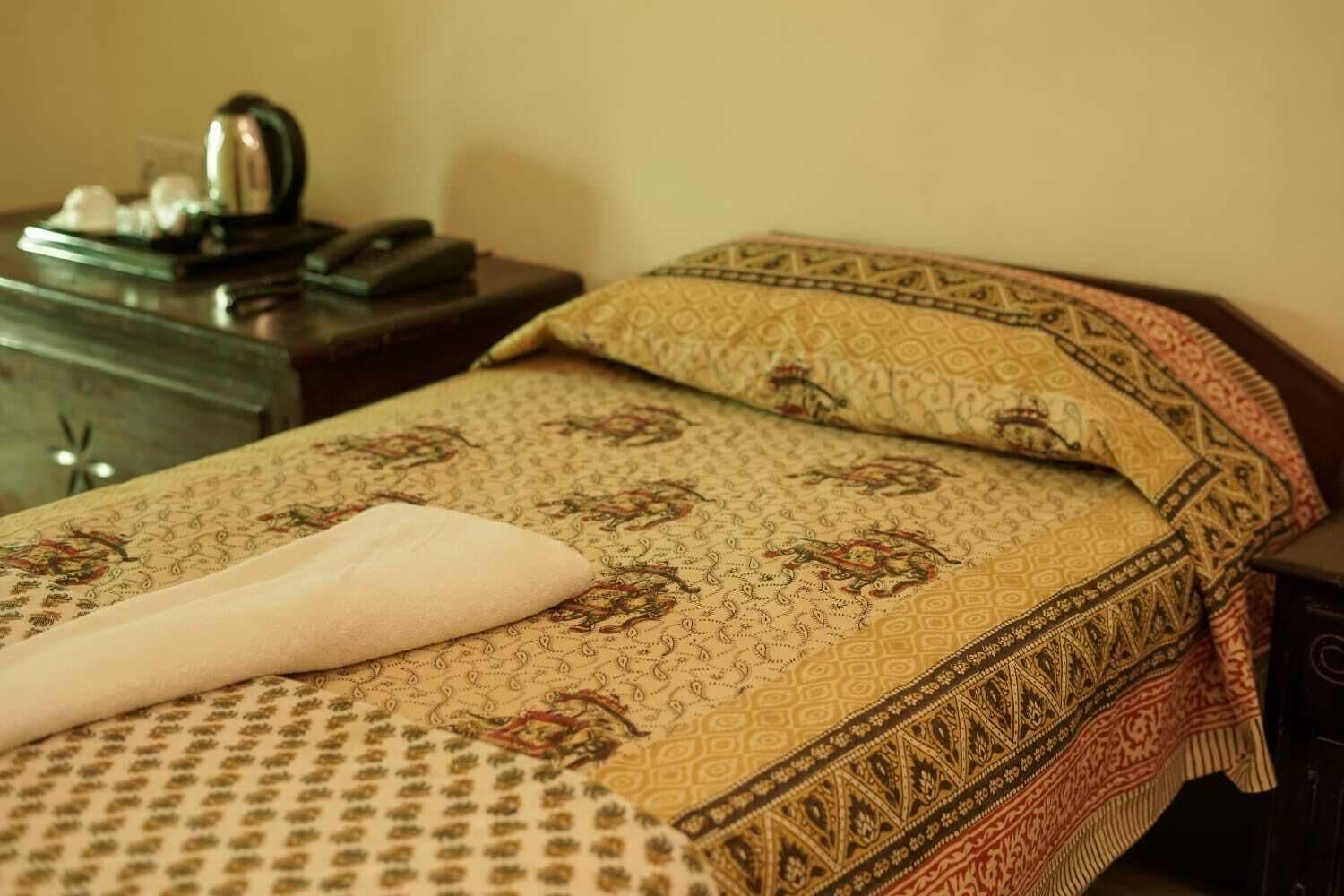 A neatly made bed with patterned bedding and a decorative pillow.