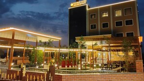 A hotel with a well-lit outdoor area, including a covered patio and a pool. - The park green hotel & resort (Chandauli)