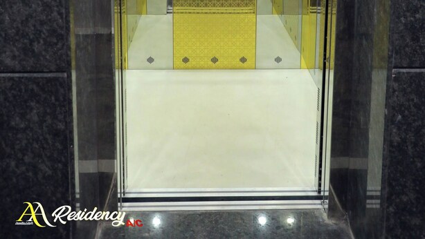 An elevator with a Buddha statue, marble walls, and a patterned floor. - AA Residency (Tirupati)