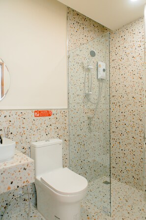 Un baño con inodoro, lavamanos y ducha.