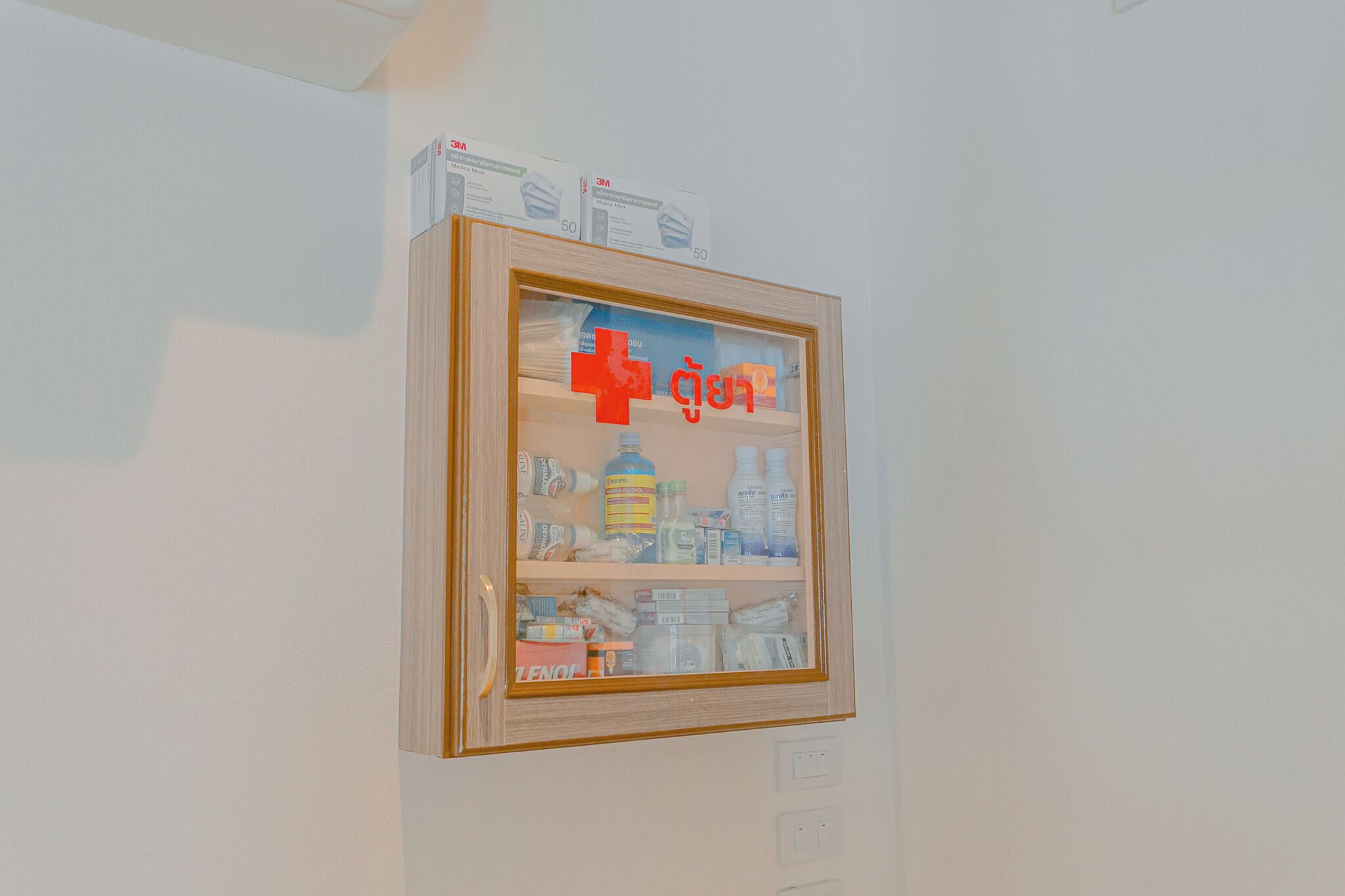 A framed display with various items on shelves, including boxes and bottles.