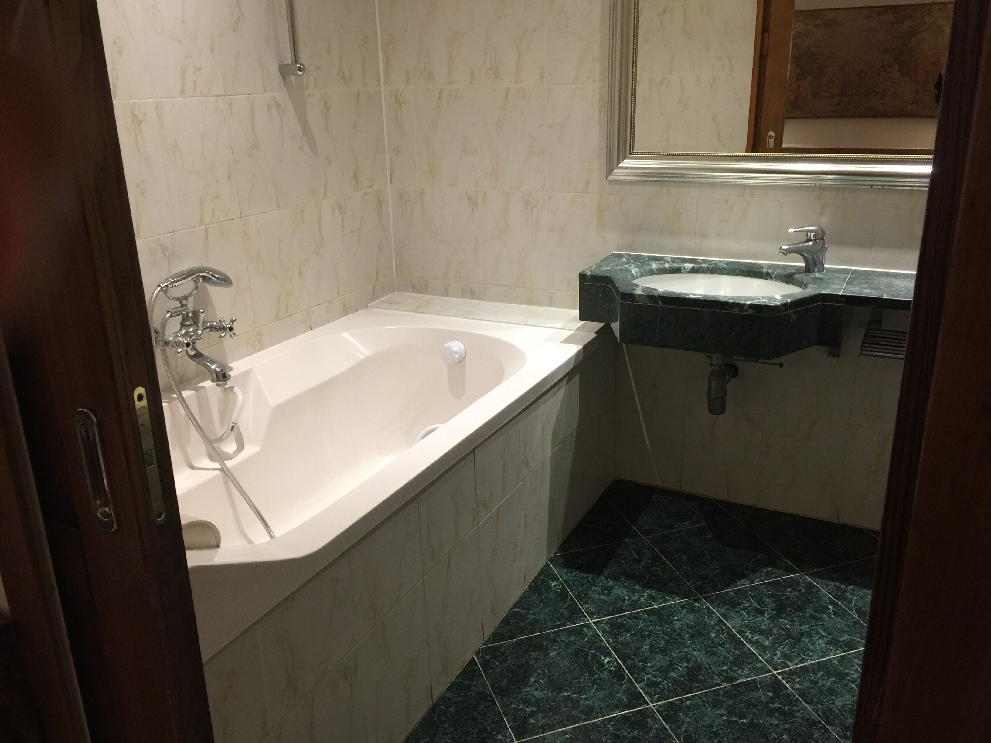Un bany amb banyera, un lavabo i una dutxa.
