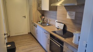 A modern kitchen with a microwave, oven, and a coffee maker. - Seeadler LH-105 - Comfortable vacation apartment with 2 terraces (Stolpe auf Usedom)