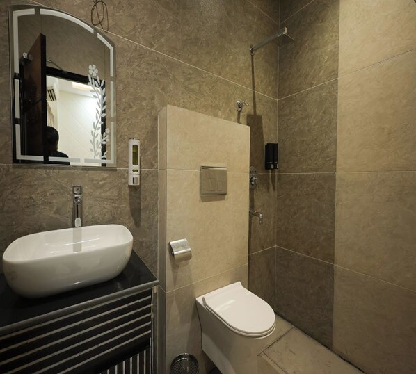 Un baño con lavamanos blanco, inodoro y ducha.