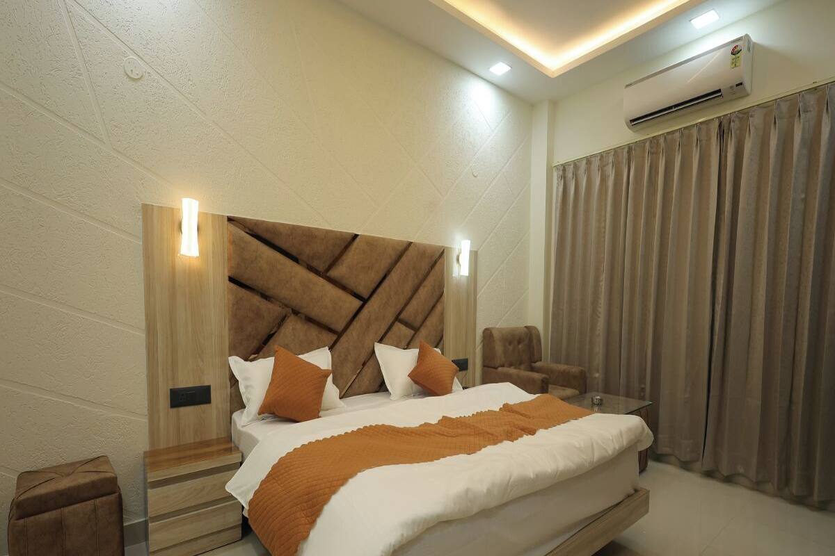 A modern bedroom with a large bed, wooden headboard, and two bedside tables.