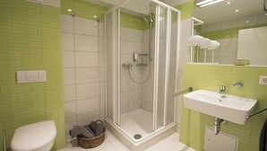 A bathroom with a shower, toilet, and sink.