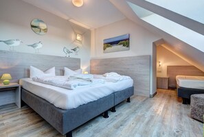 A modern bedroom with a large bed, a nightstand, a lamp, and a painting on the wall. - Windflüchter LH-305 - The country farm Windflüchter LH-305 - Family-friendly (Stolpe auf Usedom)