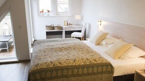 Une chambre à coucher avec un lit, une table de chevet, une lampe et une fenêtre donnant sur l’extérieur.