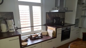 Una cocina compacta con ventana, cafetera, microondas y estufa.