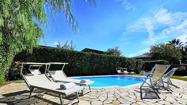 A swimming pool with lounge chairs and a stone patio. - Villa Orlando with private pool - My Rental Homes (Sant'agnello)
