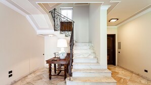 A marble staircase with a wooden table and a lamp, leading to a door. - Villa Orlando with private pool - My Rental Homes (Sant'agnello)